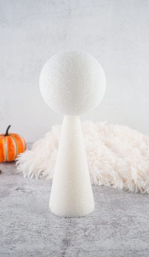 Viral Sherpa Ghost DIY Halloween craft made with fluffy white sherpa fabric, black felt eyes, and a small orange pumpkin.