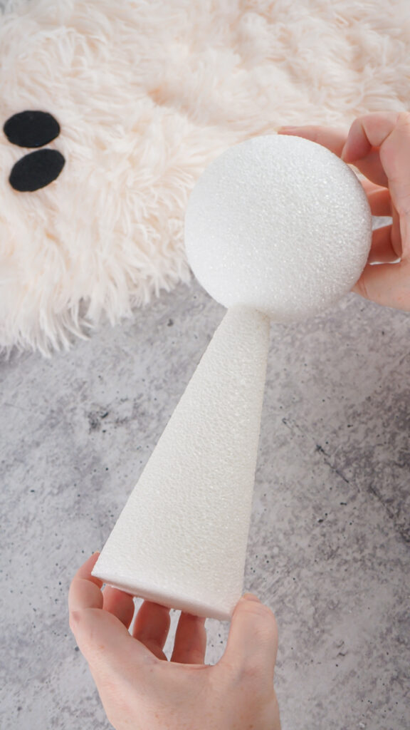 Viral Sherpa Ghost DIY Halloween craft made with fluffy white sherpa fabric, black felt eyes, and a small orange pumpkin.